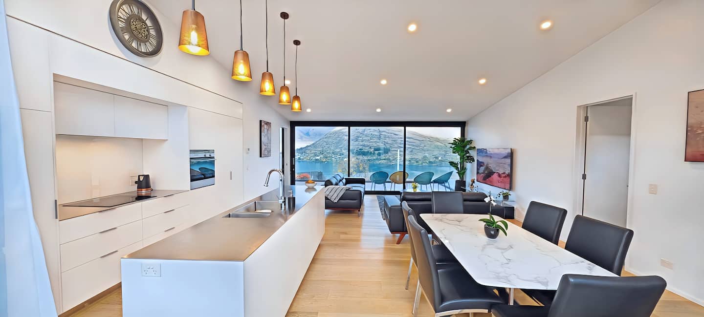 The open-plan kitchen, dining room and living area at Lakevista Retreat with lake and mountain views